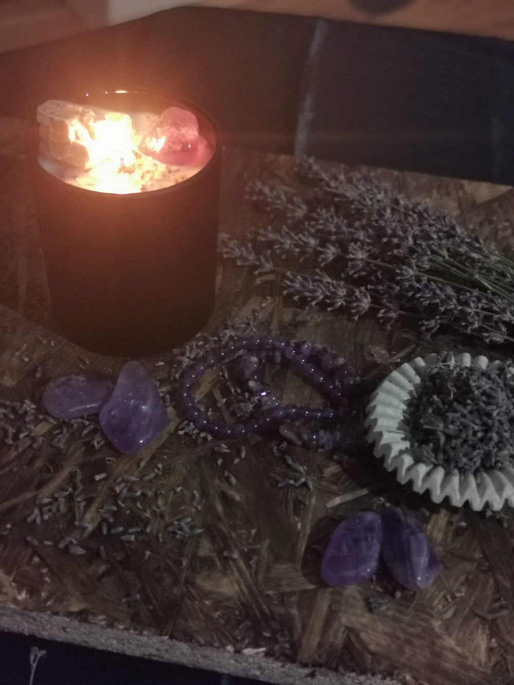LUMARAS Free Ground Ritualkerze brennend auf Holzbrett – Sojawachskerze mit Amethyst & Citrin